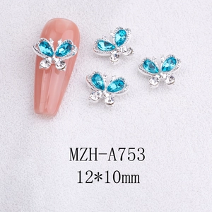 Macro detail of a 12x10mm alloy butterfly nail charm with blue rhinestones and silver base