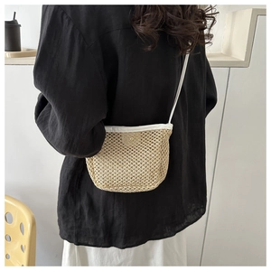 Dettaglio mini borsa a tracolla in paglia intrecciata con cinturino in pelle bianca