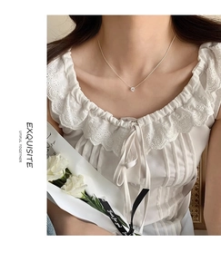 Detailed view of zircon solitaire pendant on delicate silver chain worn by a model