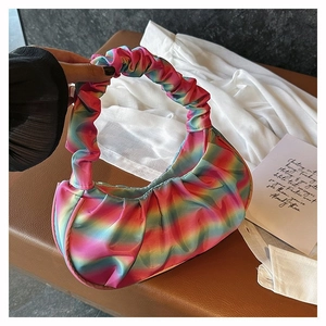 Detail of colorful rainbow gradient pleated shoulder bag with soft satin-like fabric texture