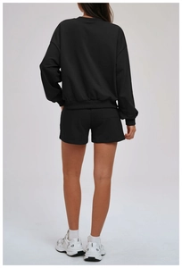 Back view of a black oversized sweatshirt and shorts set with ribbed cuffs and pocket