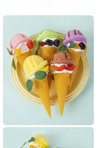 Set di cinque coni gelato colorati con guarnizioni di frutta su vassoio giallo