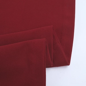 Detail of burgundy knit dress showing soft fabric texture and double-stitched hem finish