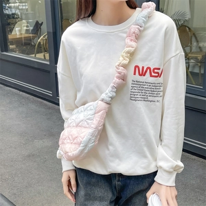 Pink and white gradient cloud bag with quilted puffer texture on a street model