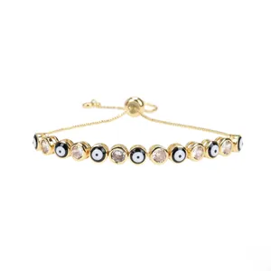 Detail of golden adjustable evil eye bracelet with enamel beads and cubic zirconia
