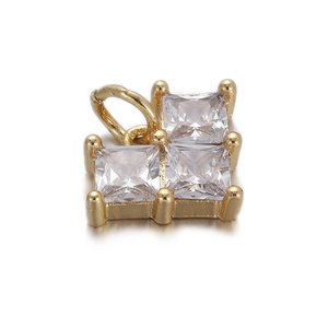 Detail of a gold-plated charm with three square-cut clear cubic zirconia on white base