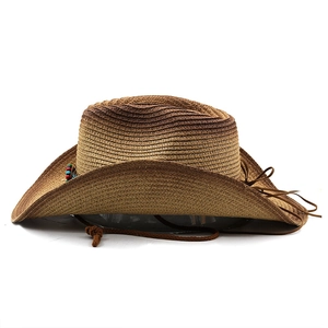 Detail of bohemian straw cowboy hat with gradient weave, beads, and leather tassels