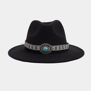Détail d'un chapeau fedora noir à larges bords avec ruban ethnique et pierre turquoise