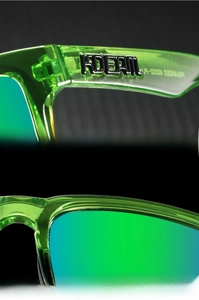 Close-up of polarized sports sunglasses showing 3D logo and green transparent frame