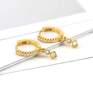 Detail view of gold S925 sterling silver hoop earrings with geometric zircon charms