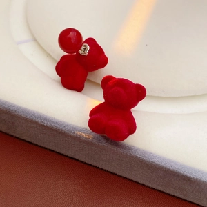 Detail view of red flocked bear earrings with a matching sphere backing on one stud
