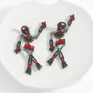 Detailed view of skull earrings featuring black metal set with red rhinestones