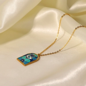 Roman arch pendant necklace with blue evil eye enamel on golden chain over silk