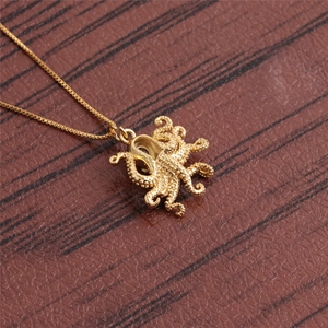 Detailed top view of a gold octopus pendant necklace with textured surface on wood