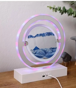 Detail of pink LED quicksand lamp base with USB and AUX ports on a white rectangular stand