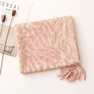 Detailed macro view of pink zebra pattern scarf with gold foil dots and fringe tassels