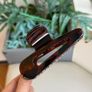Dettaglio del grande fermaglio per capelli in resina ambrata con texture tartarugata