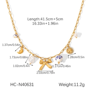 Detailed specs of gold chain necklace with moon, sun, bow pendants and ceramic beads