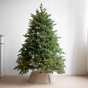 Nordic artificial Christmas tree with warm LED lights and woven rattan tree skirt base