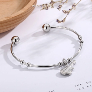 Detail view of silver stainless steel violin bracelet with delicate musical instrument charm