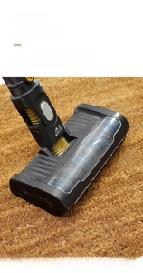 Close-up of vacuum cleaner cleaning durable natural coir fiber doormat surface