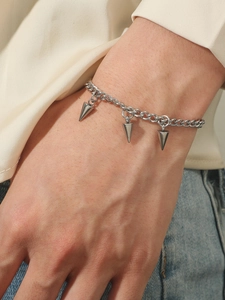 Close-up of stainless steel chain bracelet featuring three solid punk spike charms