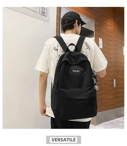 Rear view of a large black COOLBOY backpack on a model featuring an astronaut pendant