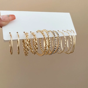 Détail d'un ensemble de 6 paires de créoles dorées avec strass et motifs torsadés chic