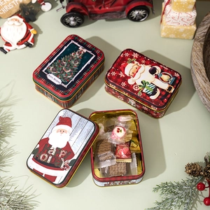 Close-up of festive Christmas tin boxes with Santa and tree motifs for gift packaging