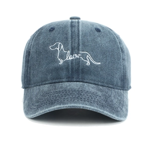 Detail shot of white dog embroidery with love lettering on a navy blue washed cotton cap