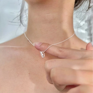 Minimalist 925 sterling silver necklace with a clear teardrop zircon pendant on woman neck