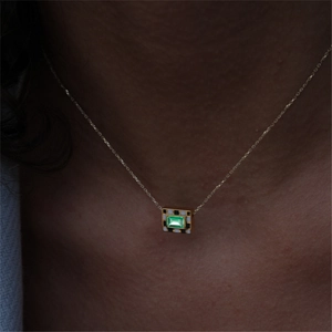Close-up of S925 silver necklace with emerald cut green gem and checkered enamel pendant