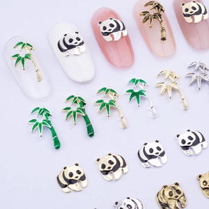 Detail view of panda and bamboo alloy nail art charms with golden finish and green enamel