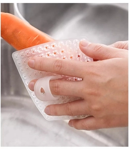 Primo piano della spazzola in silicone bianco per verdure con anello mentre pulisce carote