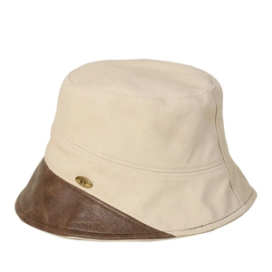 Beige cotton bucket hat with brown leather brim and gold metal logo accent
