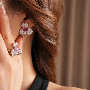 Detail shot of vintage zircon flower earrings and ring set with red gemstones
