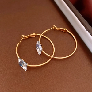 Detail of 24k gold-plated hoop earrings featuring a square-cut white zircon stone