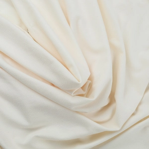 Gros plan sur un tissu en maille blanc crème avec texture drapée élégante et douce