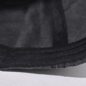 Macro shot of dark washed vintage fabric texture and reinforced stitching on baseball cap