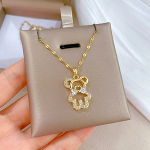 Luxurious gold bear necklace with sparkling white rhinestones on display card