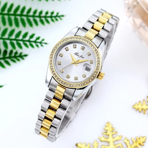 Close-up of quartz watch with silver gold strap, rhinestone bezel and date display