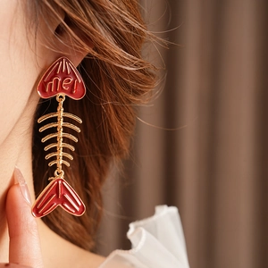 Details von kreativen Fischgräten-Ohrringen mit roter Emaille und me! Buchstabenanhängern