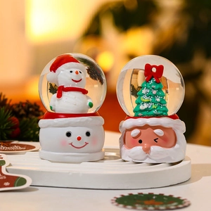 Luminous Christmas crystal balls with Santa and snowman figurines on festive bases
