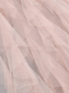 Detail of multi-layered pink mesh fabric with soft tulle texture and honeycomb pattern