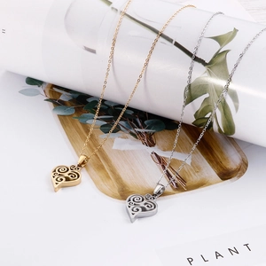 Artistic detail of gold and silver heart necklaces with hollow filigree on a wooden tray