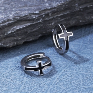 Macro shot of silver stainless steel hoop earrings with an inlaid black cross pattern