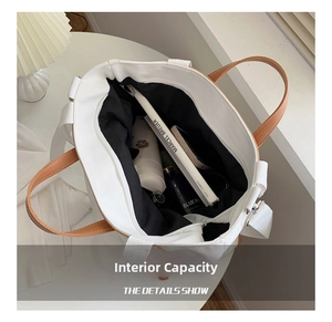Top view of white canvas tote bag showing spacious interior with books and water bottle