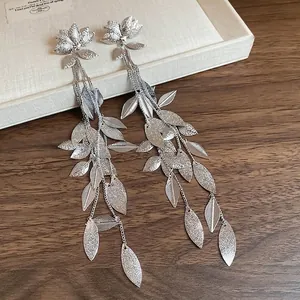 Boucles d'oreilles pampilles argentées avec clou floral et fini métal mat sur plateau