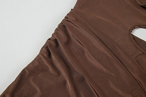 Détail du tissu froncé marron avec texture soyeuse sur une robe d'été sexy à découpes