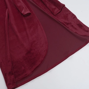 Dettaglio dell'orlo del vestito in velluto bordeaux con cuciture e texture del tessuto